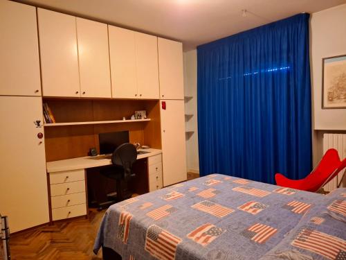 a bedroom with a bed and a desk and a blue curtain at Medusa Home & Relax in Porto SantʼElpidio
