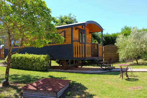 a train car sitting in a yard next to a table at Domaine de Presle Saumur, The Originals Relais in Distré