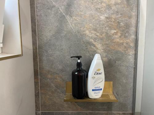 a bottle of soap and a soap dispenser on a shelf at APARTAMENT ULTRACENTRAL PREMIUM,PARCARE,WiFi in Sîngeorz-Băi