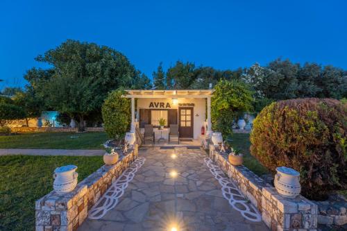 a home with a stone walkway in front of a building at SKYROS AVRA Residences in Skiros