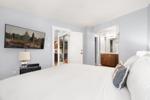 a white bedroom with a large bed and a window at Luxury 2-Bed Whistler Village in Whistler