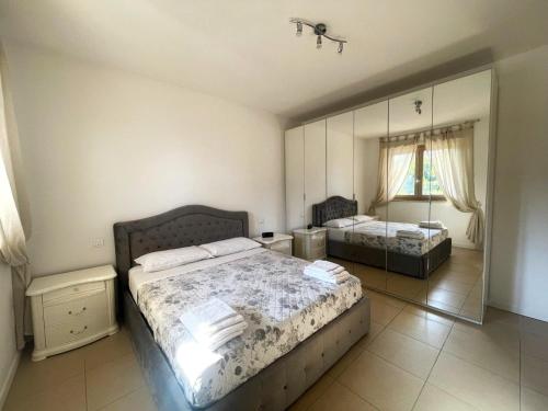 a bedroom with two beds and a large mirror at Casa Junea in Maccarese