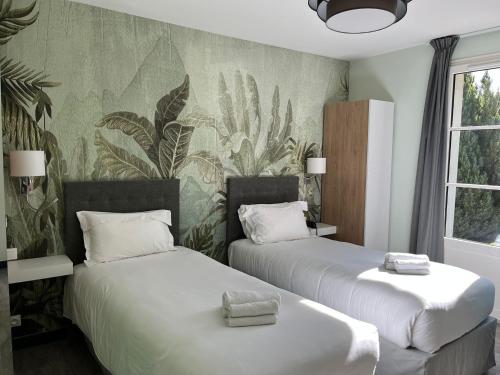 two beds in a room with plants on the wall at Domaine de Presle Saumur, The Originals Relais in Distré