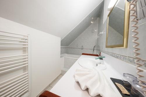 a white bathroom with a sink and a mirror at Domaine de Presle Saumur, The Originals Relais in Distré