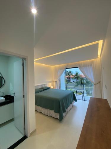 a bedroom with a bed and a large window at Casa pé na areia - Triplex - Praia do Farol Velho - Salinópolis in Salinópolis