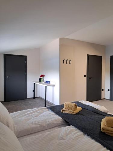 a bedroom with two beds and a table with two doors at Apartamenty Wałowa 7 in Rewa