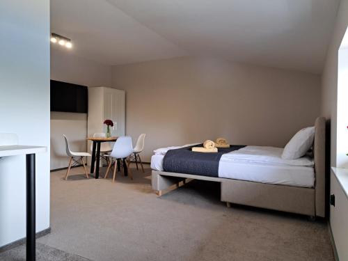 a bedroom with a bed and a table and chairs at Apartamenty Wałowa 7 in Rewa