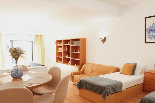 une chambre avec un lit, une table et des chaises dans l'établissement Casinha da Praia - Vila Nova de Gaia, à Vila Nova de Gaia
