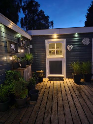 a front door of a house with potted plants at Liefdevol chalet aan het meer in Suameer