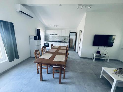 a dining room with a table and a kitchen at Gádé Apartmanház in Sukoró