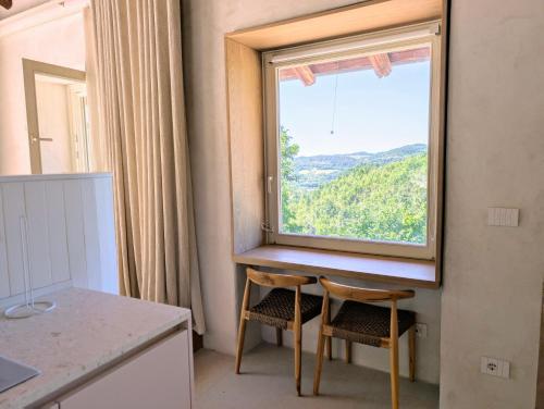 a kitchen with a table and two chairs and a window at Cascina Le Moire in Merana