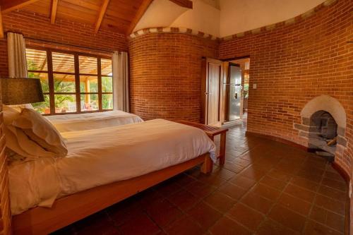 a bedroom with a bed and a brick wall at David's Den Atitlán in Panajachel
