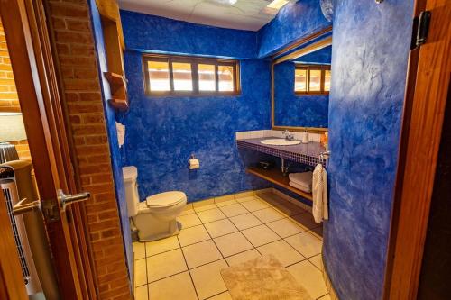 a blue bathroom with a toilet and a sink at David's Den Atitlán in Panajachel