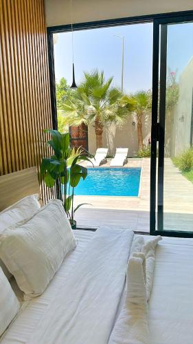 a bedroom with a large bed and a swimming pool at شاليه فندقي غرفتين نوم مسبح وبانيو in Banī Ma‘n