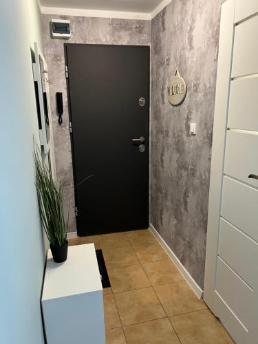a black door in a hallway with a white table at Apartament Piaskowa Mountain & Coffee in Wałbrzych