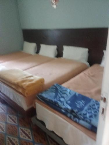 two beds sitting next to each other in a room at Hôtel des cedres azrou in Oulad Akkou