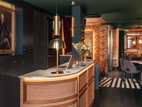 un bar dans un restaurant avec un ordinateur portable sur un comptoir dans l'établissement Snob Hotel, à Paris