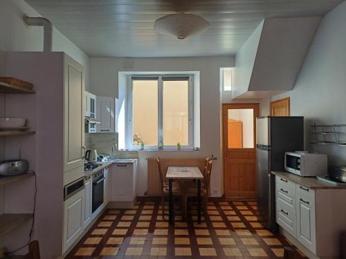 a kitchen with a table and a refrigerator at Villa Estelle et villa Jean, ensemble de 2 villas Wimereusienne in Wimereux