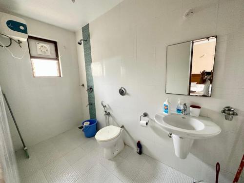 a bathroom with a sink and a toilet and a mirror at Beachside luxury getaway in Cana