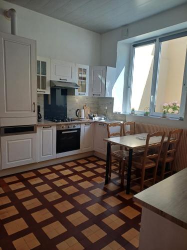 a kitchen with white cabinets and a table and chairs at Villa Estelle et villa Jean, ensemble de 2 villas Wimereusienne in Wimereux