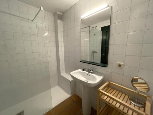 a white bathroom with a sink and a mirror at CARGOL by SOM Menorca in Fornells
