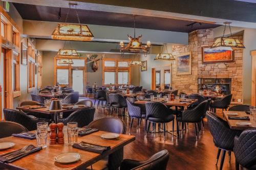 a restaurant with wooden tables and chairs and a brick wall at Flying Saddle Resort and Steak House in Alpine