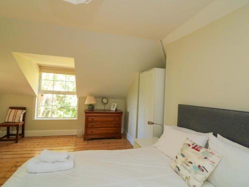a bedroom with a white bed and a window at Savernake in Thurlestone