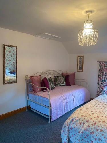 a bedroom with a bed and a chandelier at Village Cottage 5 minutes to Alton Towers in Alton