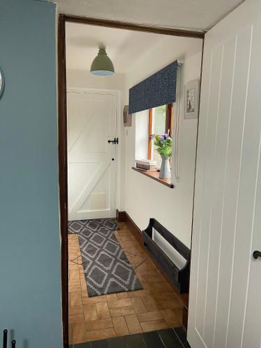 a hallway with a white door and a window at Village Cottage 5 minutes to Alton Towers in Alton