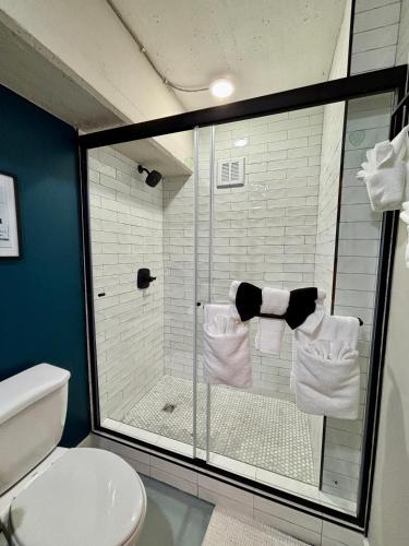a bathroom with a shower and a toilet with towels at The Monarch Unit 8 in Huntsville