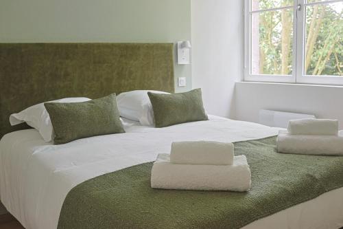 - un grand lit blanc avec 2 serviettes pliées dans l'établissement La Suite des Martyrs - Centre Ville - Elégant, à Bordeaux