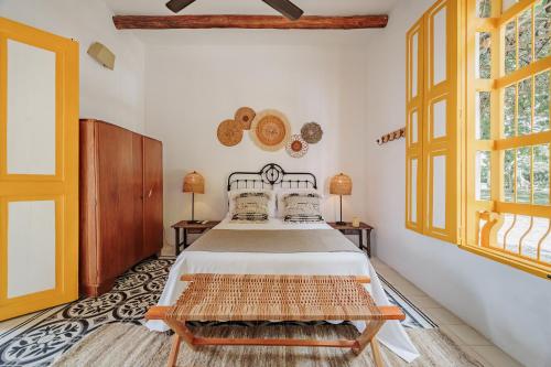 a bedroom with a bed and two windows at Hotel Fundadores en Cauca Viejo Fundadores in Jericó