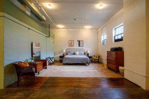une chambre avec un lit et un bureau dans une pièce dans l'établissement Downtown Lynchburg, Vault Loft, 1,500 sq. ft., Va, à Lynchburg