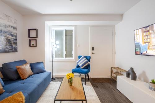 a living room with a blue couch and a table at Amazing 4 Bedroom Unit in Downtown in Montréal