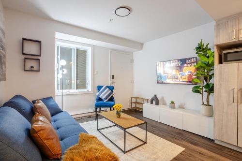 a living room with a blue couch and a table at Amazing 4 Bedroom Unit in Downtown in Montréal