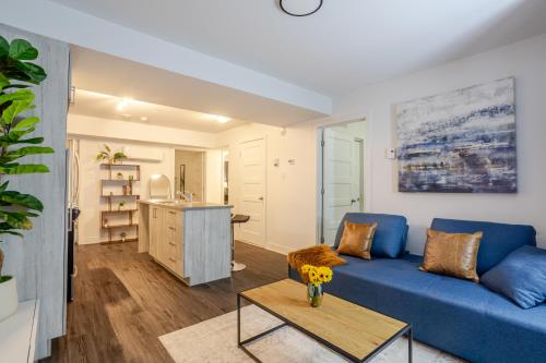 a living room with a blue couch and a table at Amazing 4 Bedroom Unit in Downtown in Montréal