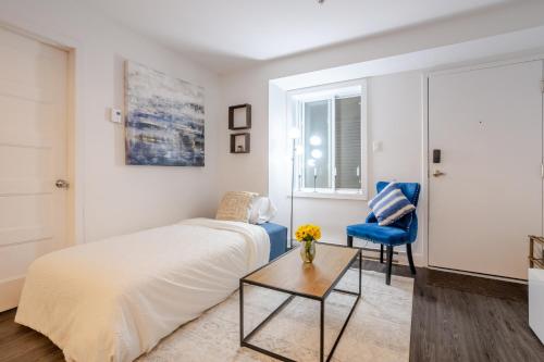 a bedroom with a bed and a blue chair at Amazing 4 Bedroom Unit in Downtown in Montréal