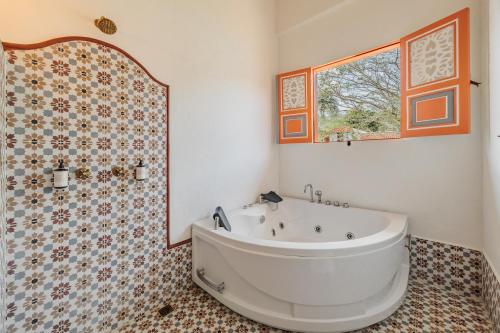 a bathroom with a tub and a shower with a window at Hotel Fundadores en Cauca Viejo Fundadores in Jericó