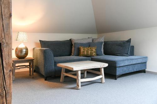 a living room with a blue couch and a table at Historischer Gasthof Zum Anker Wachau in Wachau