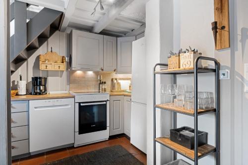 a small kitchen with white appliances and a shelf at Trysilfjell Nord 1105C - by Vacation Trysil in Trysil