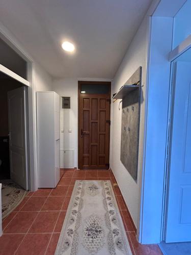 a hallway with a brown door and a tile floor at Apartment Alisa in Vlasic