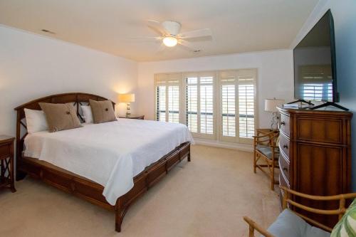 Un dormitorio con una cama, una cómoda y un televisor. en 145 Ocean Point Dr, en Fripp Island