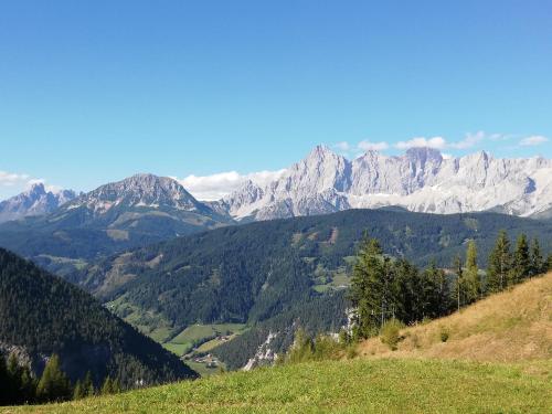 a view of a mountain range from a grassy hill at Gästehaus Pürstl-Kocher in Schladming