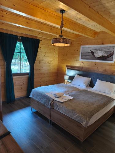 a bedroom with a bed in a wooden cabin at Wood Fairy 2 in Korenica