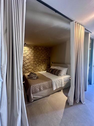 a bed with white curtains in a bedroom at Linen by Goutos Luxury Living in Kranidi