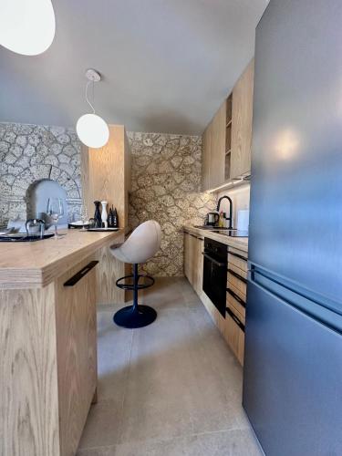 a kitchen with a refrigerator and a chair in it at Linen by Goutos Luxury Living in Kranidi