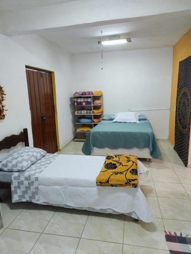 a bedroom with two beds and a closet at kitnet Silva Guedes in São Thomé das Letras