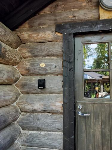 a door to a log cabin with a window at Kuukkelin Koto in Hämeenlinna