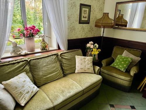 a living room with a couch and a window at Villa Antica in Kudowa-Zdrój