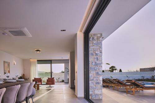 a living room with a stone pillar and chairs at Manza Villa in Sfakaki
